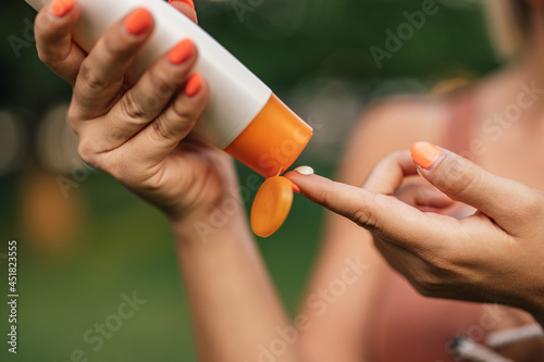 Close-up image of a woman putting on sun lotion. photo