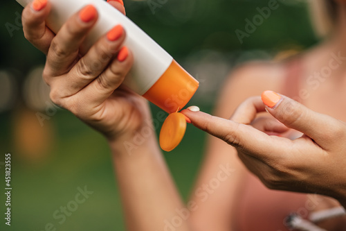 Close-up image of a woman putting on sun lotion.