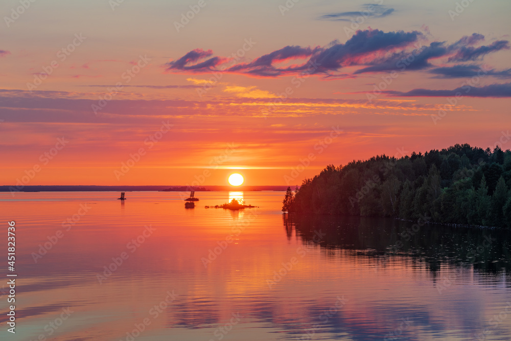 Beautiful bright sunset on the river with reflection in the water.