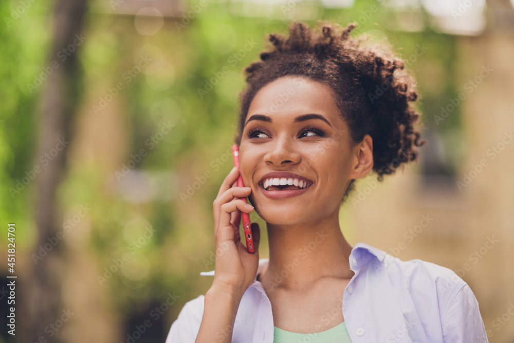 Photo of young cheerful afro woman happy positive smile communicate speak roaming cellphone outdoors Photo of young cheerful afro woman happy positive smile communicate speak roaming cellphone outdoors