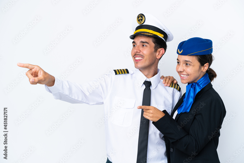 Airplane pilot and mixed race air hostess isolated on white background pointing to the side to present a product Airplane pilot and mixed race air hostess isolated on white background pointing to the side to present a product