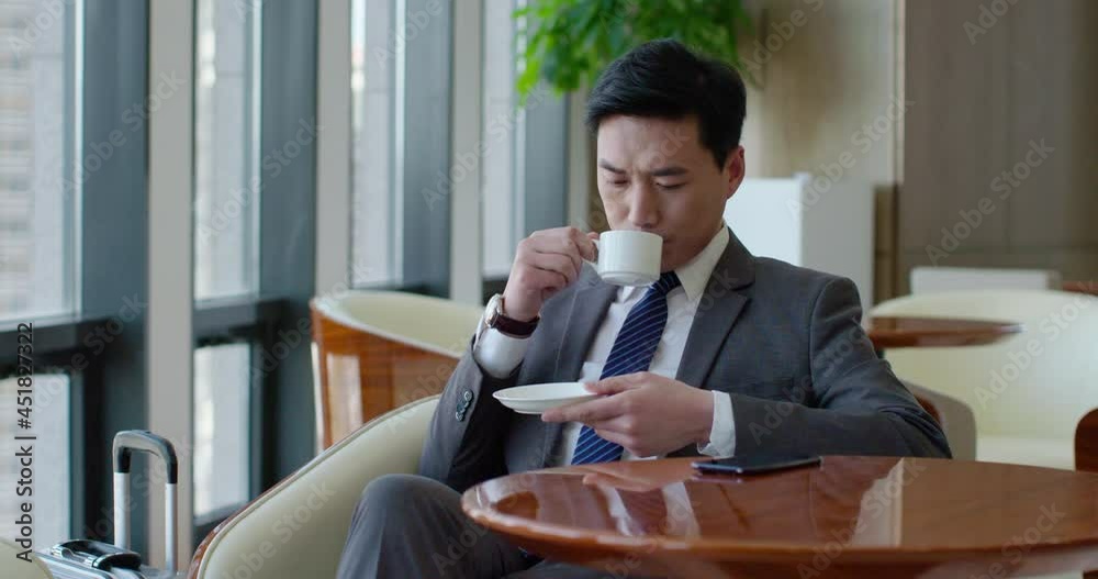 Confident businessman drinking coffee in airport lounge,4K