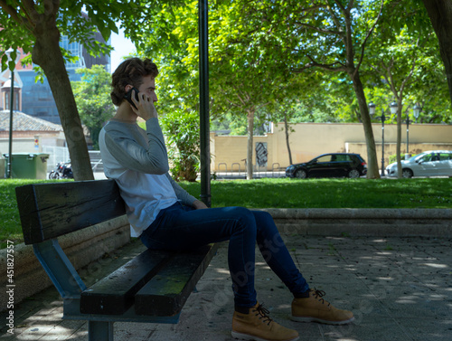 Obraz na płótnie man talking on the phone, sitting in the park w salonie