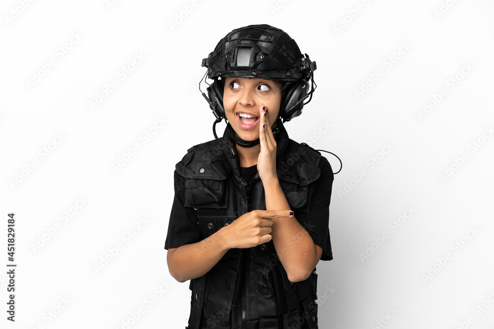 SWAT woman isolated on white background pointing to the side to present a product and whispering something SWAT woman isolated on white background pointing to the side to present a product and whispering something