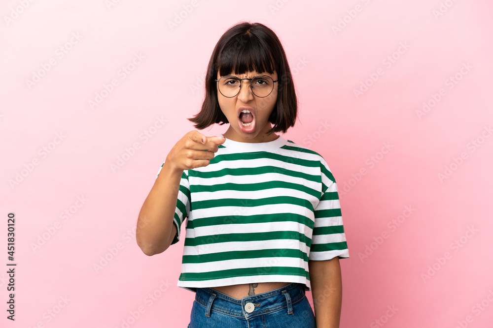 Young mixed race woman isolated on pink background frustrated and pointing to the front Young mixed race woman isolated on pink background frustrated and pointing to the front