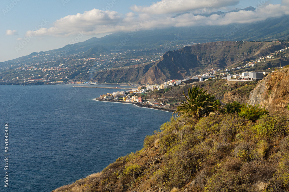 View along the westcoast of La Palma with the capital Santa Cruz, the Atlantic Ocean and the volcanic mountains in the background.