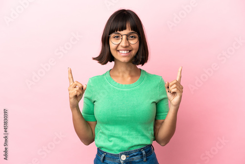 Young mixed race woman isolated on pink background pointing up a great idea