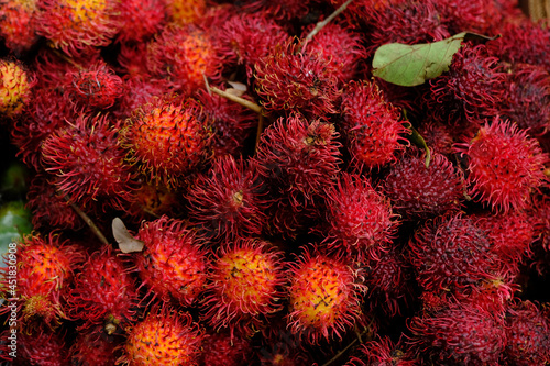 Close-up shot of Chinese rambutan hairy fruit at a street stall © Sergio