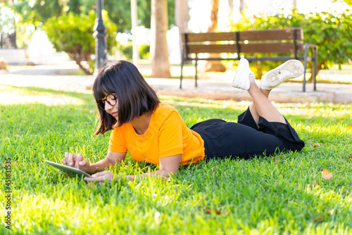 Young brunette woman at outdoors holding a tablet