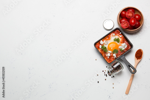 Fried eggs with tomatoes and cheese in a frying pan. Shakshuka, a Jewish dish. 