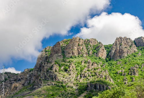 Mountain peaks covered with forest against the blue sky.