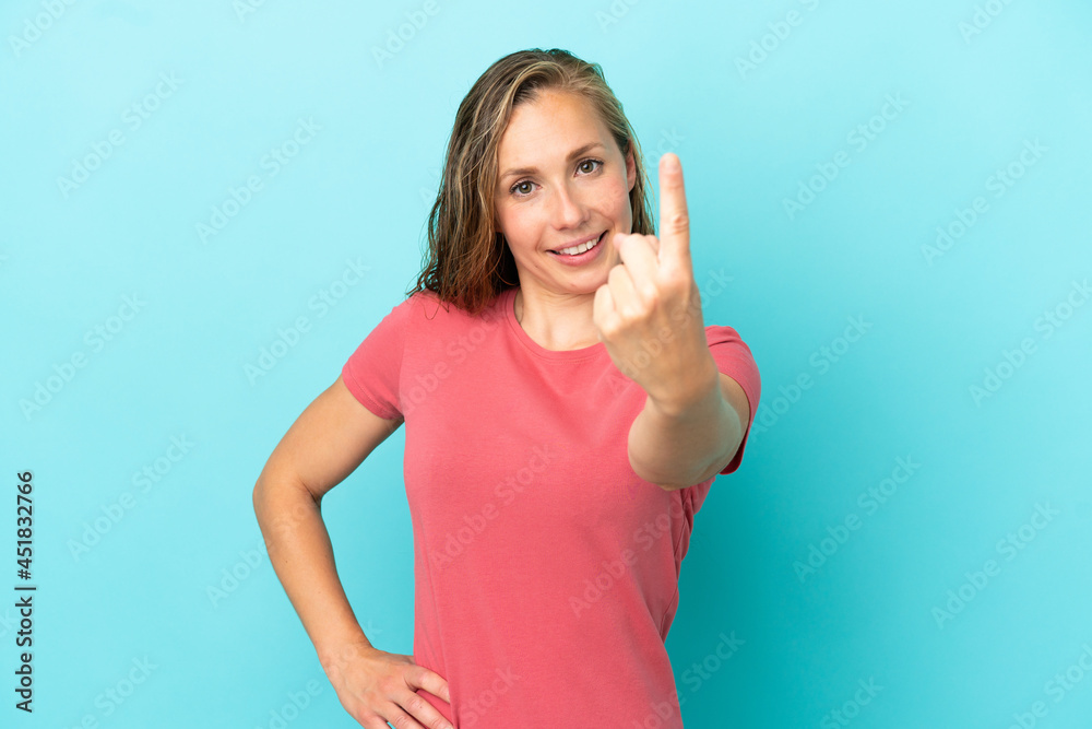 Young caucasian woman isolated on blue background doing coming gesture Young caucasian woman isolated on blue background doing coming gesture