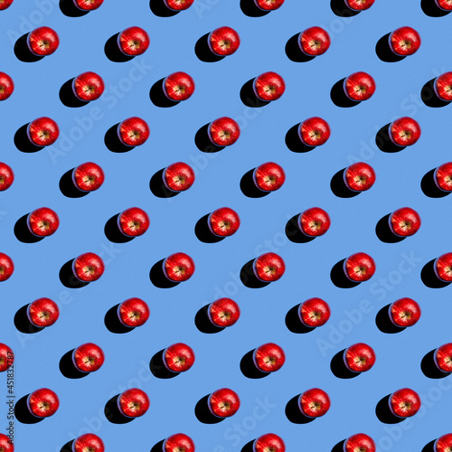 Pattern from red tomatoes on a blue background, flat lay. View from above.