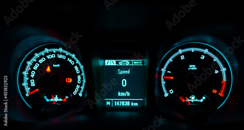 car speedometer that shows details of the car, speed, distance, etc., on a dark background.