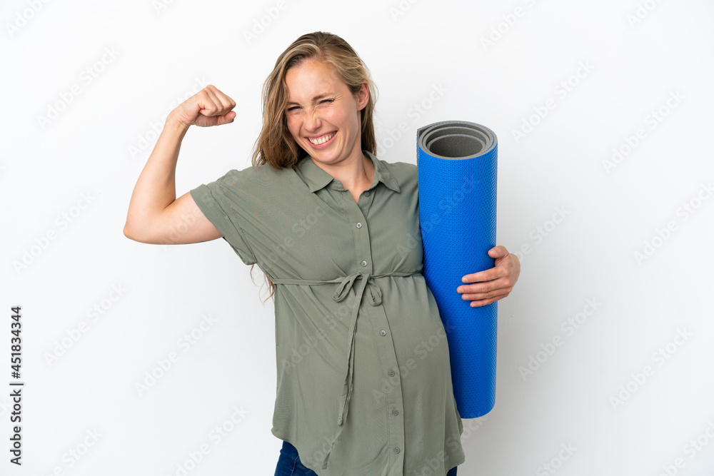 Young caucasian woman isolated on white background pregnant and doing strong gesture while going to yoga classes
