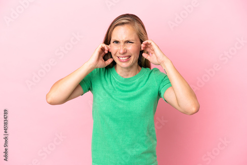 Young English woman isolated on pink background frustrated and covering ears