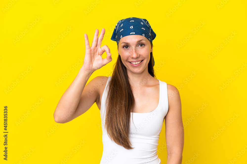 Young English woman isolated on yellow background showing ok sign with fingers