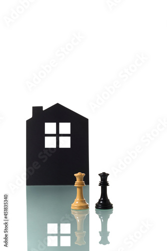 Chess pieces with silhouette of a house in the background. photo