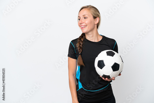 Young football player woman isolated on white background looking to the side and smiling © luismolinero