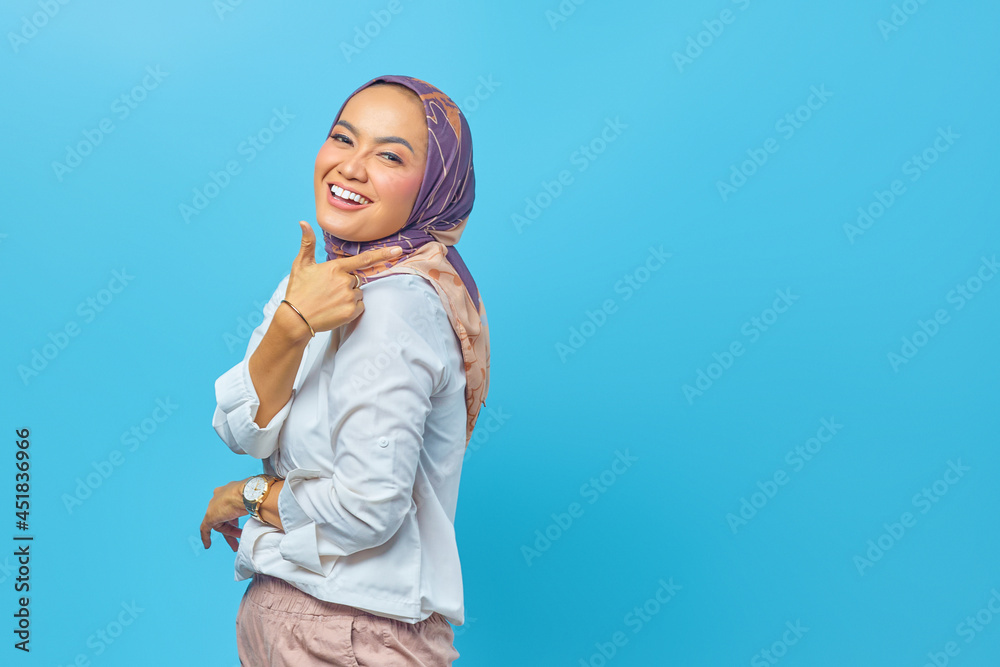 Beautiful Asian woman smiling and pointing to empty space