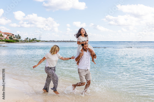 Familia multiracial jugando en las playas de Cancún, México