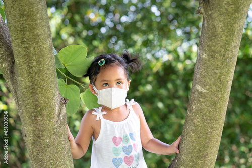 Beautiful Southeast Asian female standing between the trees in ThailandA photo