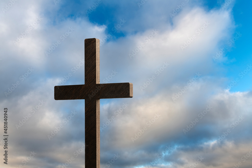 Religious cross against blue, cloudy sky
