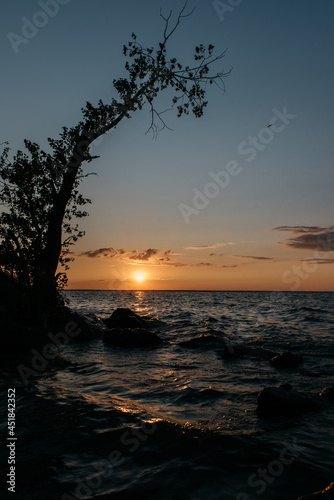 Photo of a Summer Sunset on the Lake. Travel location of popular tourist outdoor. View of beautiful Sea Landscape. Relax vacation near water