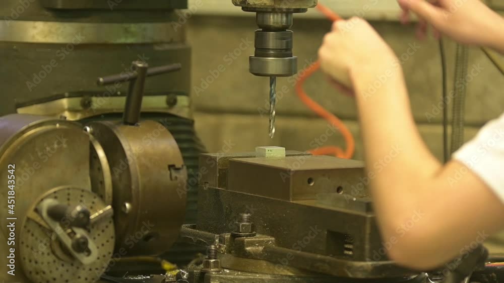 Taladro de mesa haciendo un hueco en un bloque de metal