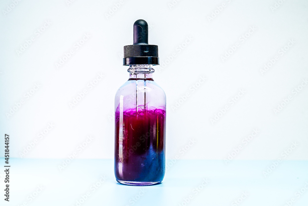 glass flask with purple paint on white background