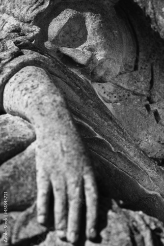 Fragment of an ancient stone statue of sad and desperate woman on tomb as a symbol of death and the end of human life. Selective focus on eye