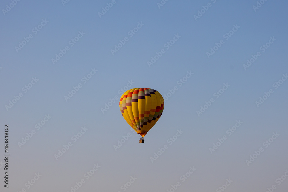 Colorful yellow and red hot air balloons over blue sky in California Colorful yellow and red hot air balloons over blue sky in California