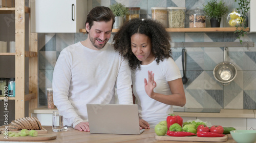 Mixed Race Couple Doing Video Call on Laptop in Kitchen