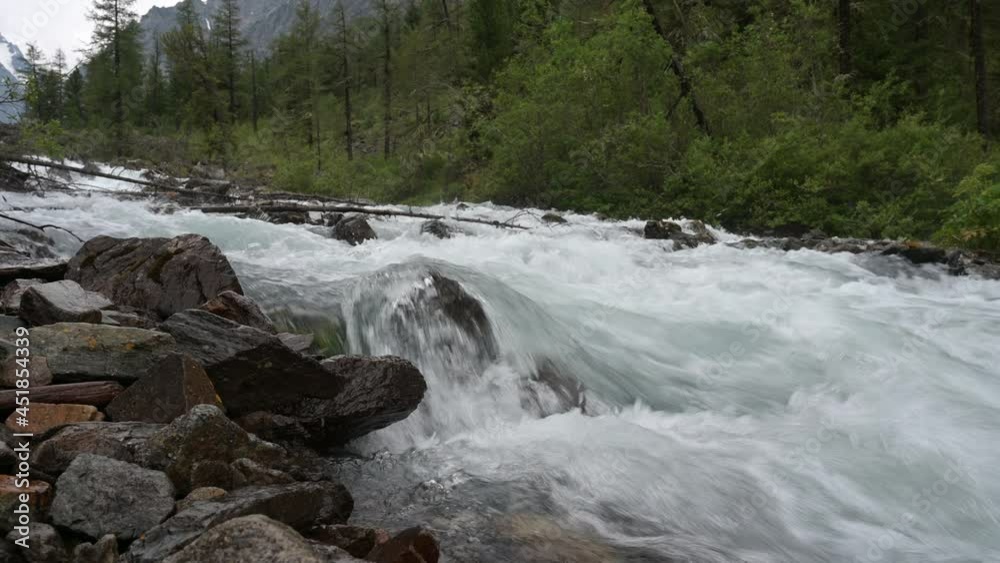 Fast mountain river flows between stones Fast mountain river flows between stones