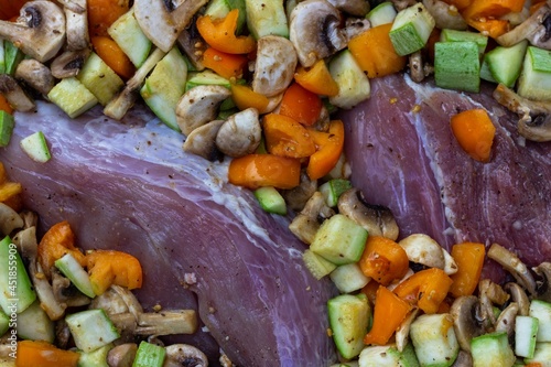 Meat and sliced ​​yellow tomatoes, courgettes and mushrooms before roasting. Flatlay
