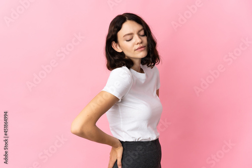 Teenager Ukrainian girl isolated on pink background suffering from backache for having made an effort