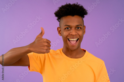 Afro man showing a thumbs up to the camera.