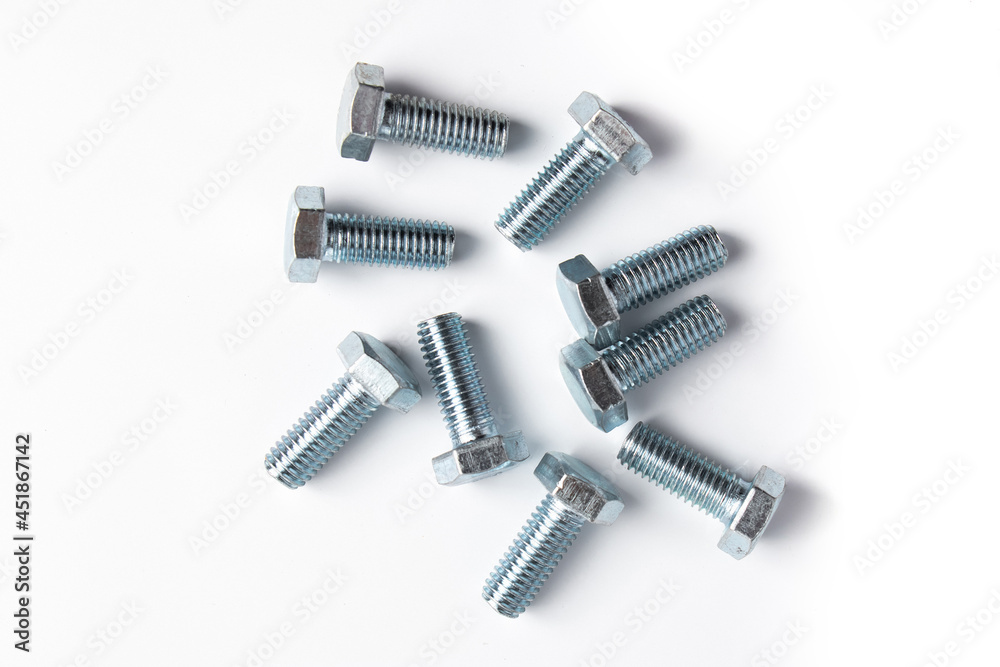 New metal bolts on a white background. Set of building tools for repair. New metal bolts on a white background. Set of building tools for repair.