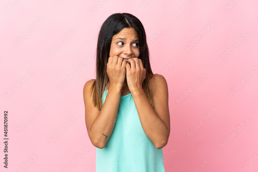 Caucasian girl isolated on pink background nervous and scared putting hands to mouth Caucasian girl isolated on pink background nervous and scared putting hands to mouth