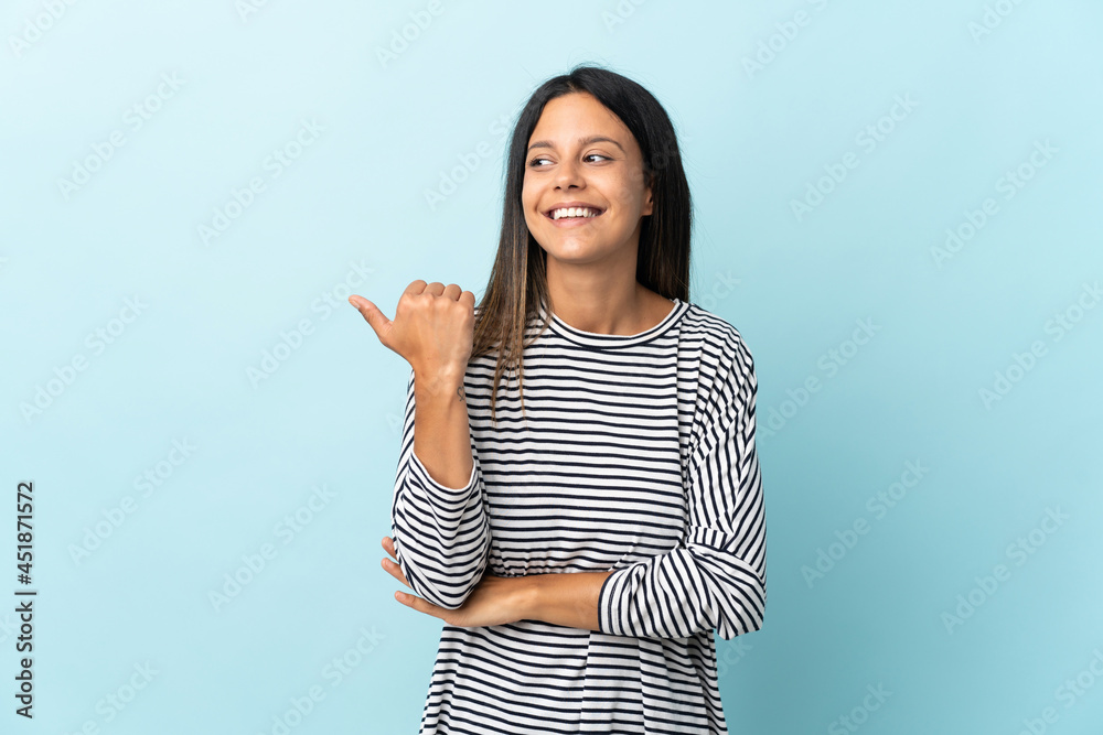 Caucasian girl isolated on blue background pointing to the side to present a product Caucasian girl isolated on blue background pointing to the side to present a product