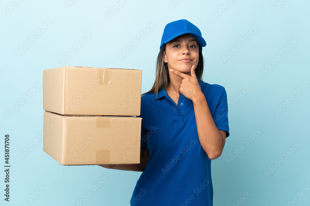 Young delivery woman isolated on blue background thinking Young delivery woman isolated on blue background thinking
