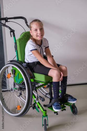 Special child on wheelchair. Girl in school uniform on the background of the school board.