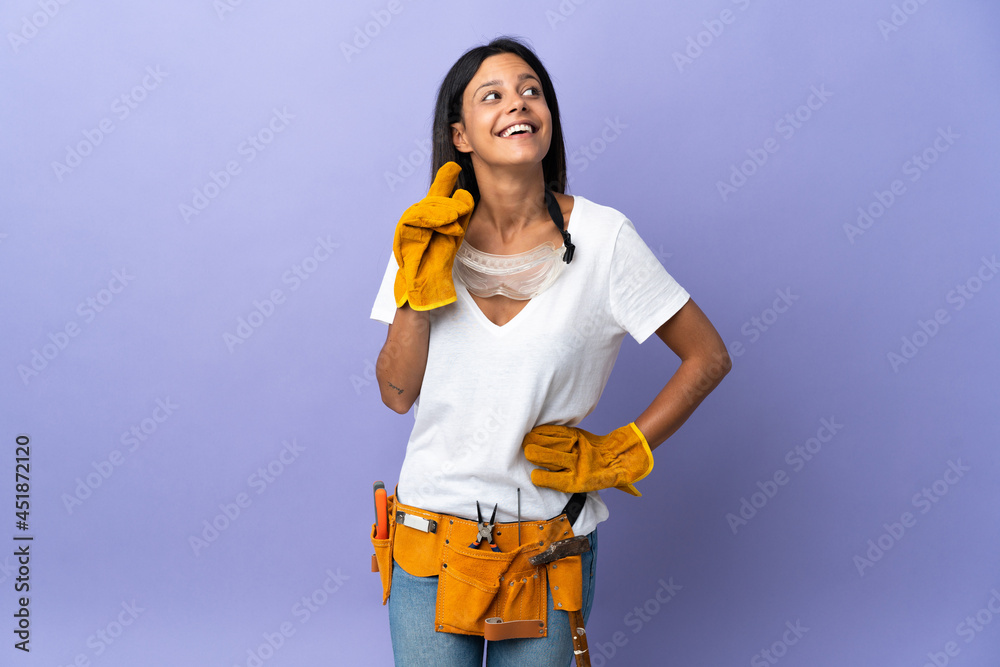Young electrician woman isolated on purple background thinking an idea while looking up Young electrician woman isolated on purple background thinking an idea while looking up