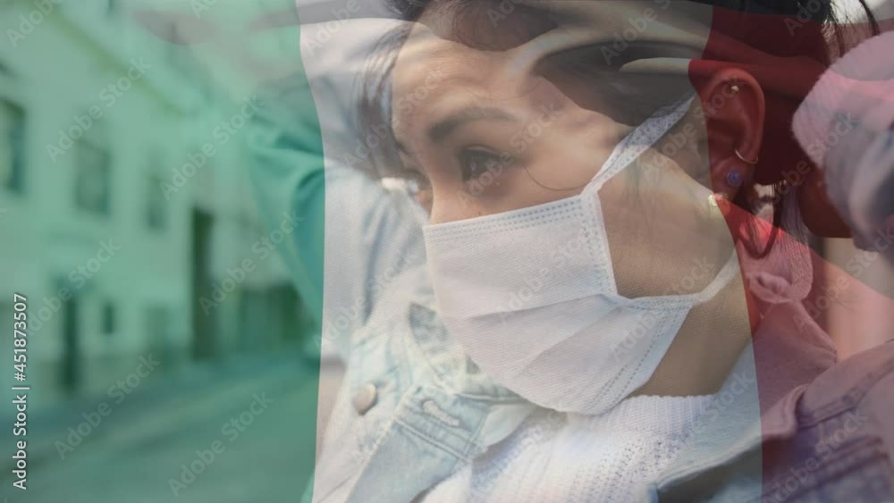 Animation of flag of italy waving over woman in face masks Animation of flag of italy waving over woman in face masks