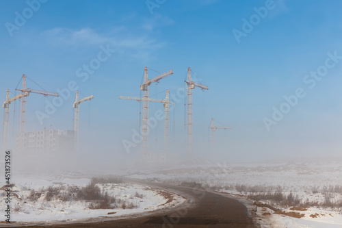 construction cranes on a construction site in winter