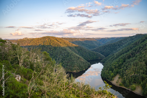 Start of golden hour on the landscape with reflection in water, end of July 2021