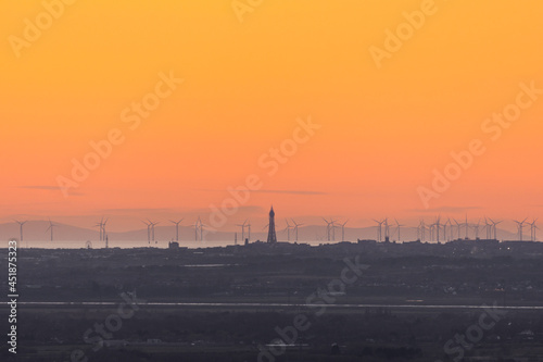 View over the Blackpool promenade from a distance showing the Blackpool Tower, Fylde Coast, wind turbines and the Isle of Man in the distance, UK
