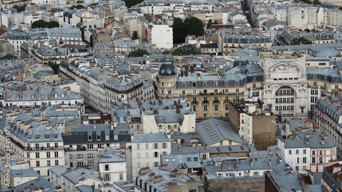 Aerial panorama of the capital of France, Paris. Summer cityscape , view of a big city from bird's eye vantage point with many old houses and horizon line.