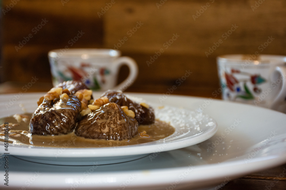 Traditional turkish dessert on plate, fig dessert and in background turkish coffee in cup Traditional turkish dessert on plate, fig dessert and in background turkish coffee in cup