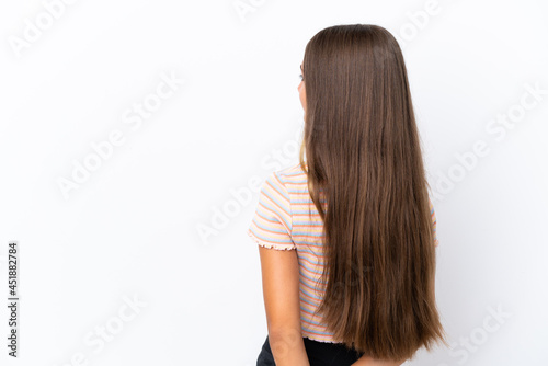 Little caucasian girl isolated on white background in back position and looking back
